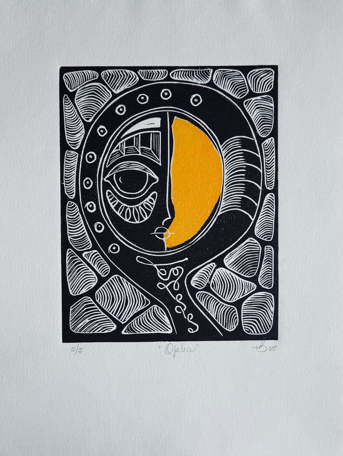 Black and white linocut of mask within circular frame with golden moon on right half and ornamental carved border, edition 5/5, artwork 'Ophelia' by Thania Liz Rojo, 2025